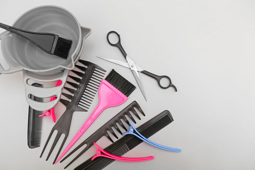 Hairdresser set with various accessories on grey background